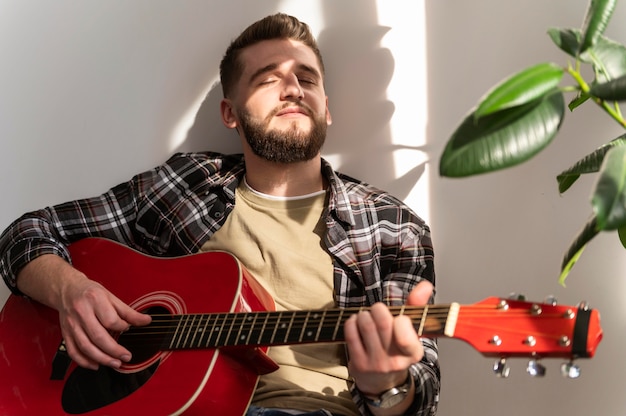 Uomo che suona il colpo medio di chitarra