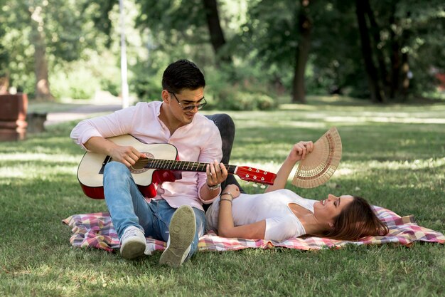 Uomo che suona la chitarra a una donna