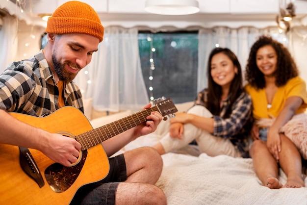 Uomo che suona la chitarra e donne che ascoltano al chiuso