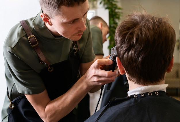 Uomo che taglia i capelli di un cliente