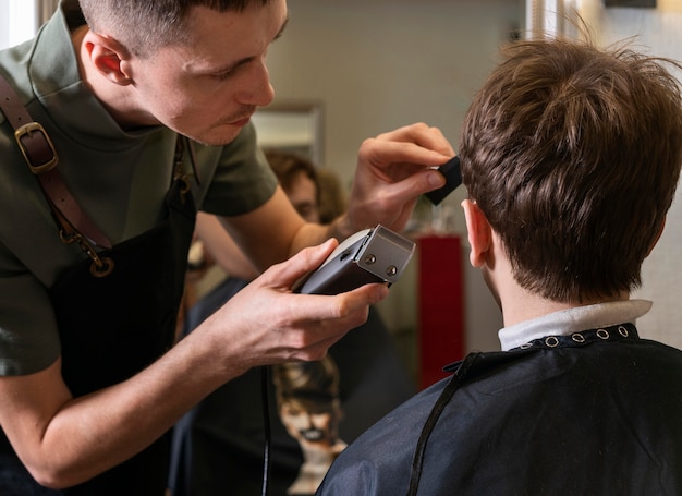 Uomo che taglia i capelli di un cliente