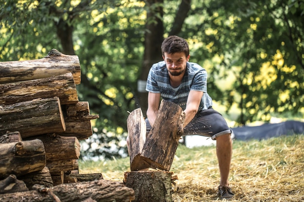 Uomo che taglia legno a pezzi con un'ascia