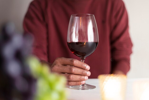 Uomo che tiene bicchiere di vino rosso