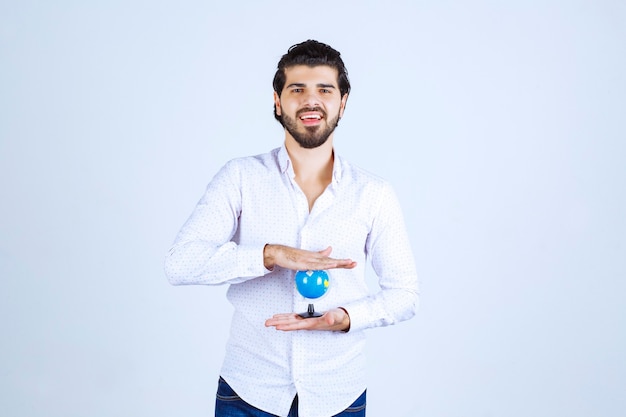 Uomo che tiene il globo del mondo tra le mani