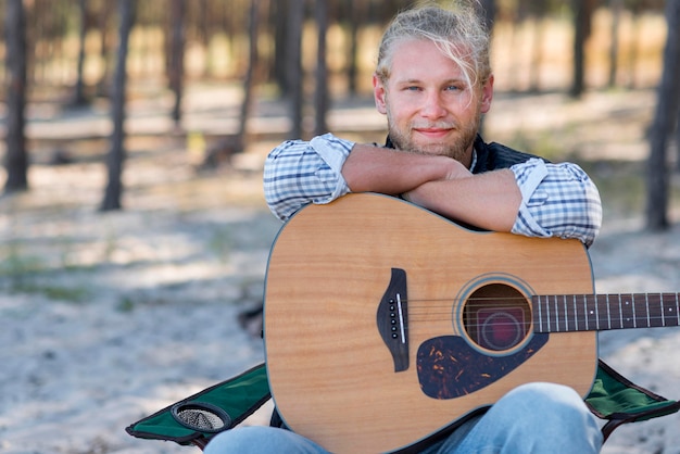 Uomo che tiene la sua chitarra acustica