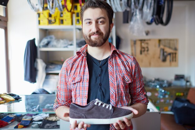 Uomo che tiene le sue nuove scarpe da ginnastica