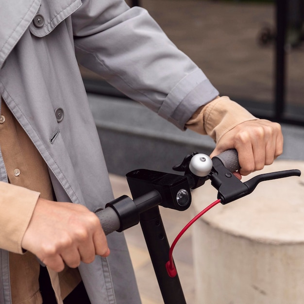 Uomo che tiene scooter elettrico per la maniglia