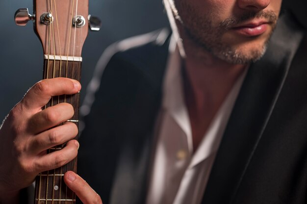 Uomo che tiene un accordo sul primo piano della chitarra