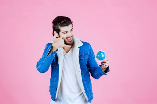 Uomo che tiene un globo e chiede una chiamata