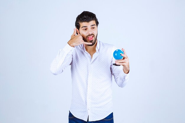 Uomo che tiene un globo e chiede una chiamata