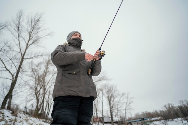 Uomo che tiene una canna da pesca