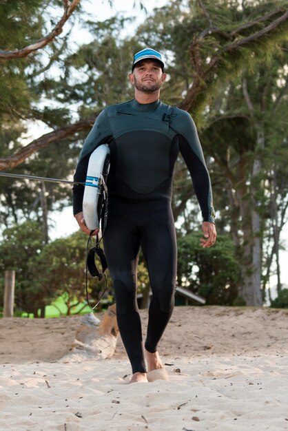 Uomo che tiene una tavola da surf all'aperto