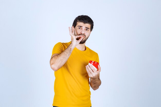 Uomo che tiene una tazza da caffè e si gode il gusto.