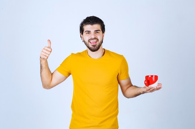 Uomo che tiene una tazza da caffè e si gode il gusto.