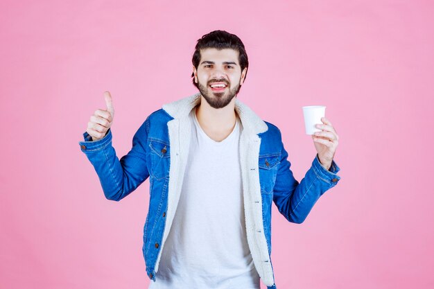 Uomo che tiene una tazza di caffè e si gode il gusto