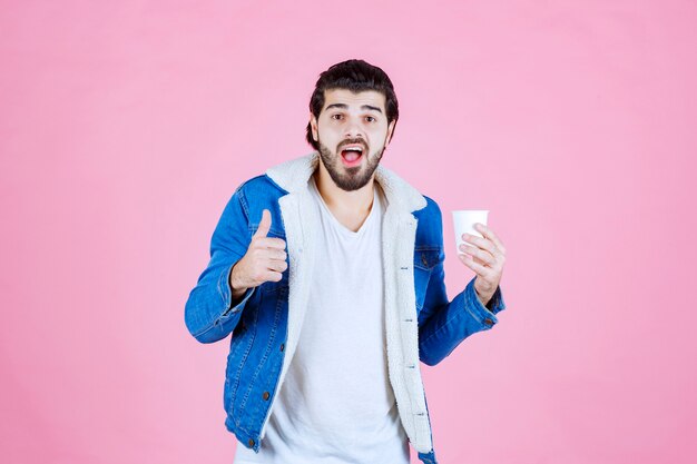 Uomo che tiene una tazza di caffè e si gode il gusto