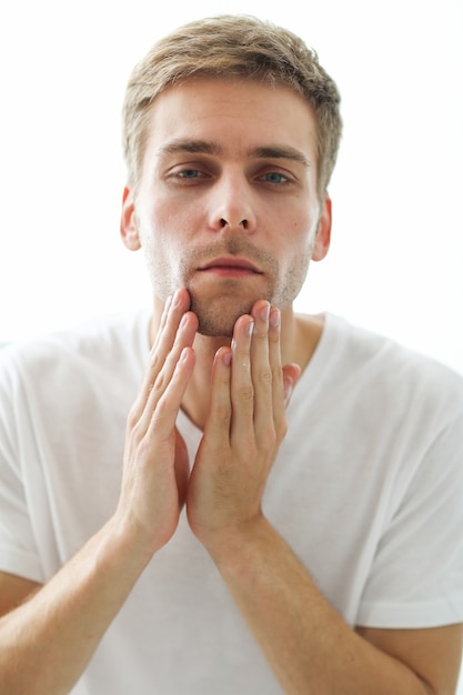 Uomo che tocca la barba, pronto per la rasatura.