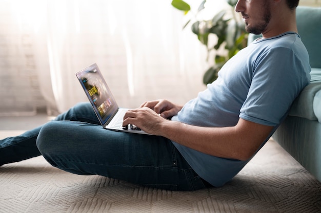 Uomo che usa il suo laptop con l'assistente digitale a casa