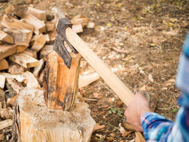 Uomo che usando un'ascia per tagliare il legno