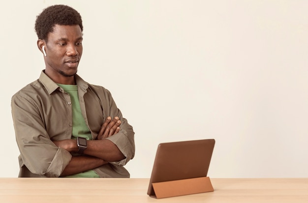 Uomo che utilizza aria baccelli e guardando la tavoletta digitale