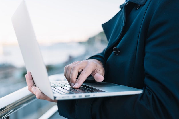 Uomo che utilizza computer portatile in ambiente urbano