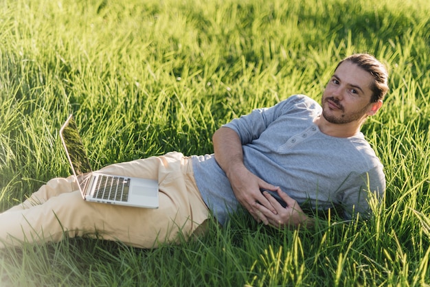 Uomo che utilizza computer portatile nel parco