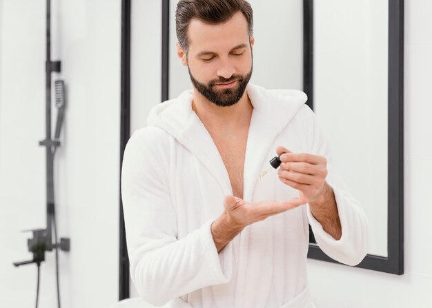 Uomo che utilizza oli naturali per il viso