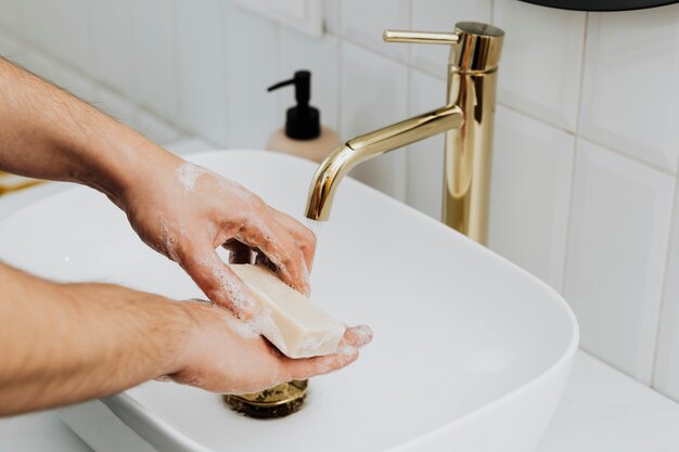 Uomo che utilizza una saponetta per lavarsi le mani