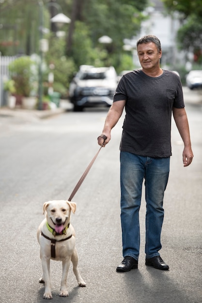 Uomo che va a fare una passeggiata con il suo cane all'aperto