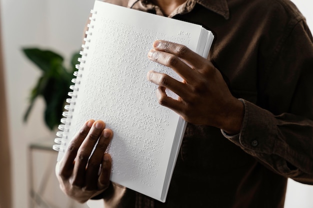 Uomo cieco che legge braille con le mani