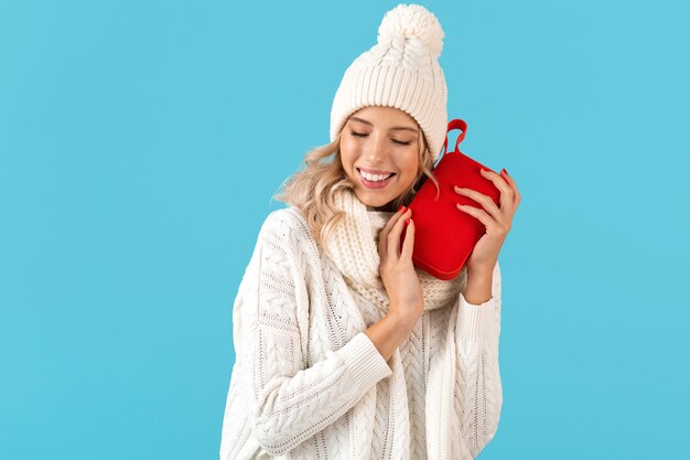 uomo con altoparlante wireless che ascolta musica felice che indossa un maglione bianco su blue