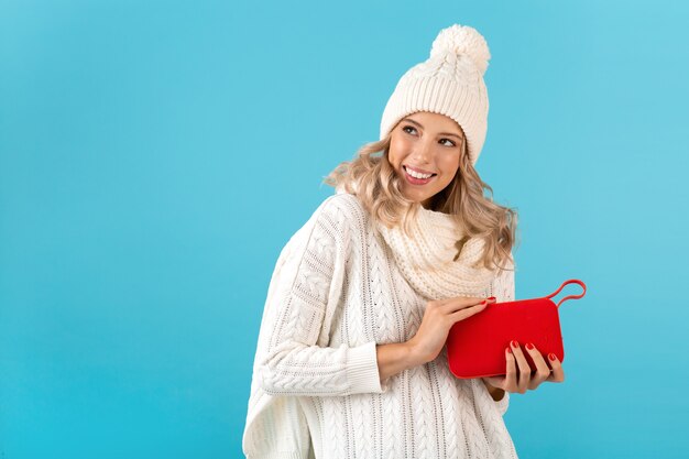 uomo con altoparlante wireless che ascolta musica felice che indossa un maglione bianco su blue
