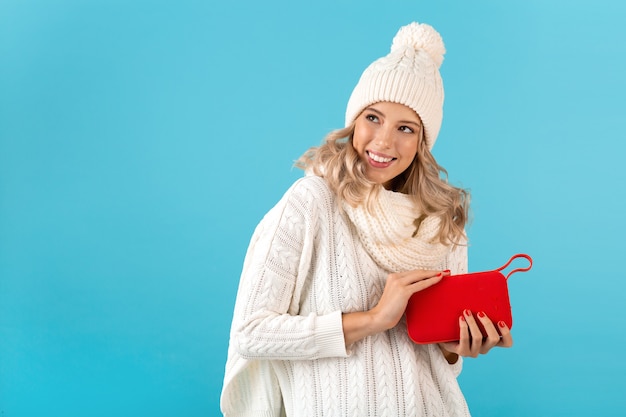 uomo con altoparlante wireless che ascolta musica felice che indossa un maglione bianco su blue