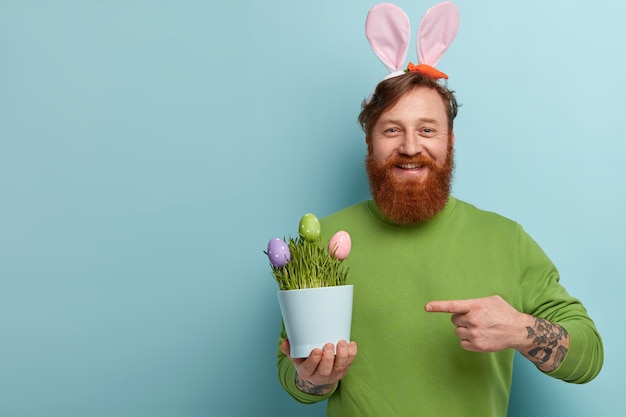 Uomo con barba allo zenzero che indossa abiti colorati e orecchie da coniglio