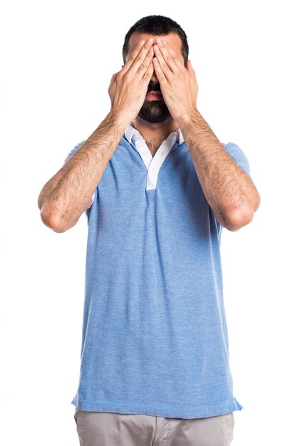 Uomo con camicia blu che copre gli occhi