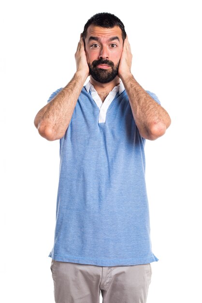 Uomo con camicia blu che copre le orecchie