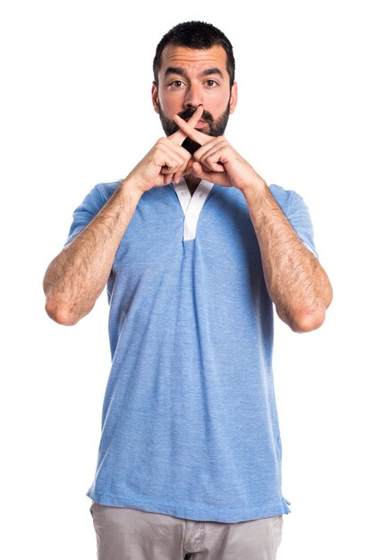 Uomo con camicia blu che fa gesto di silenzio