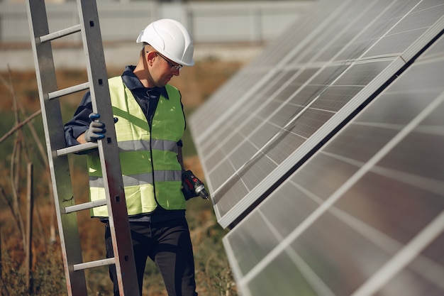 Uomo con casco bianco vicino a un pannello solare