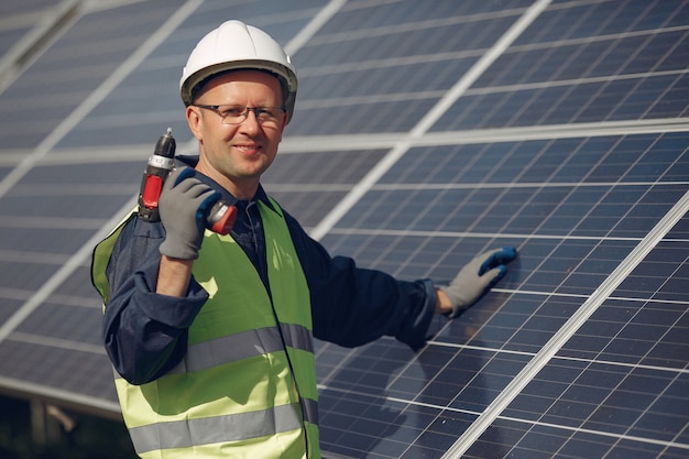 Uomo con casco bianco vicino a un pannello solare