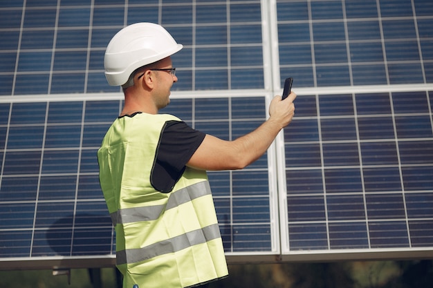 Uomo con casco bianco vicino a un pannello solare