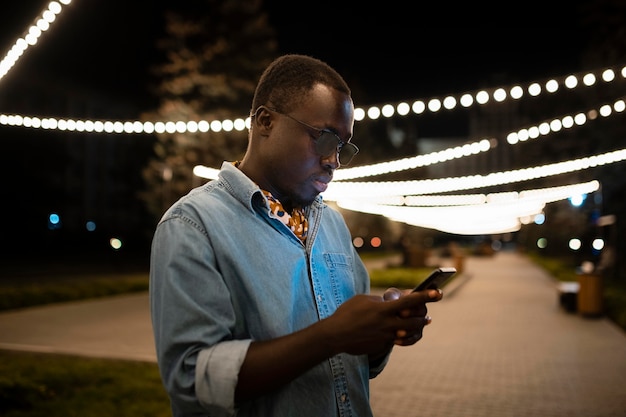 Uomo con colpo medio che tiene il telefono