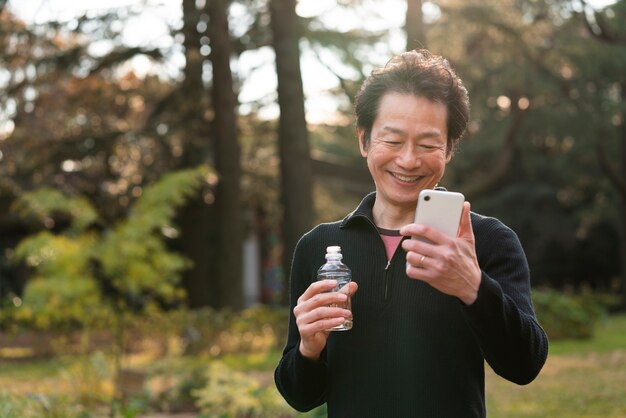 Uomo con colpo medio che tiene smartphone