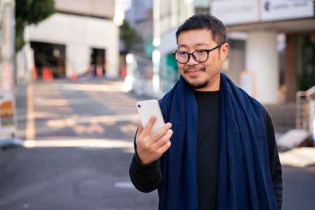 Uomo con colpo medio che tiene smartphone