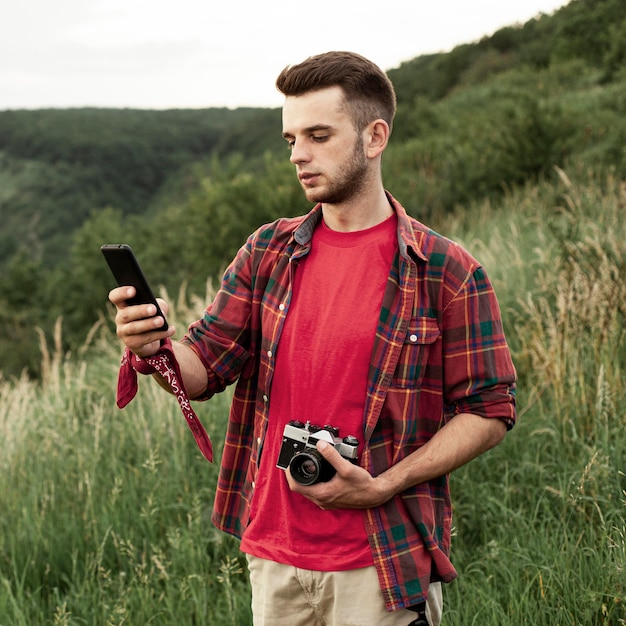 Uomo con fotocamera e cellulare