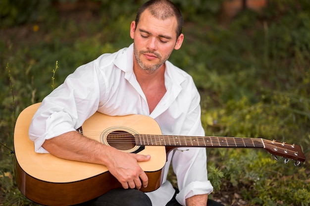 Uomo con gli occhi chiusi che tiene una chitarra