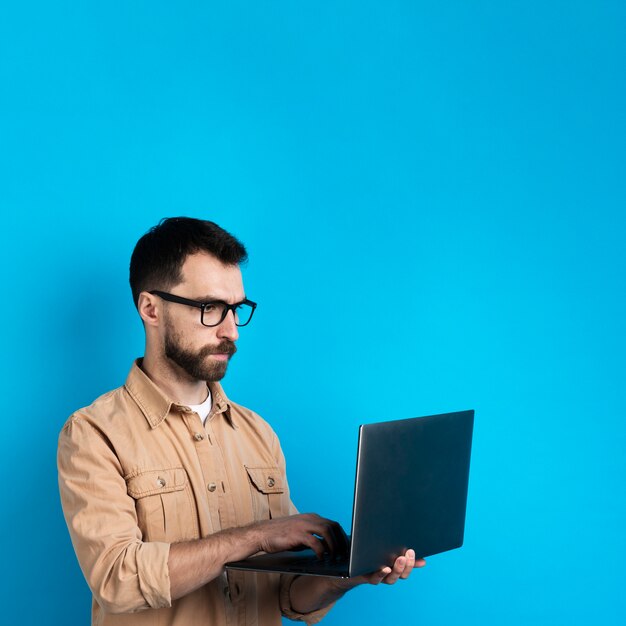 Uomo con gli occhiali che lavora al computer portatile
