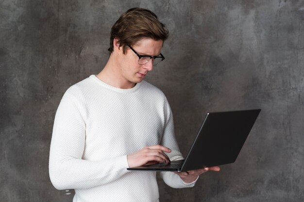 Uomo con gli occhiali, esaminando il suo computer portatile