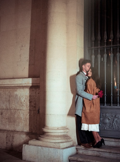 Uomo con i fiori che bacia la donna sulla fronte