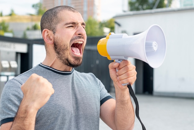 Uomo con il megafono che grida alla protesta