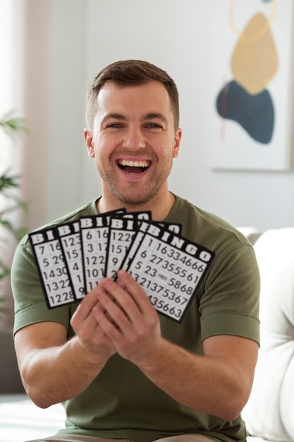 Uomo con in mano le carte da bingo colpo medio